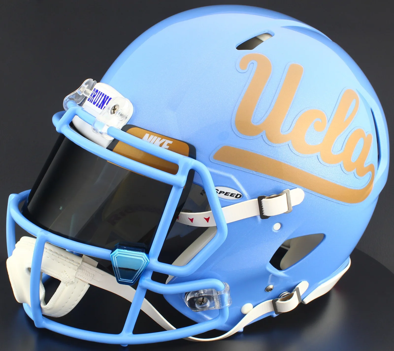 UCLA Bruins Riddell Replica Speed Football Helmet – Gold Script UCLA, Tar Heels Blue Mask, Nike Black Visor, Old Gold Brow Tabs, and Blue Chrome Clips